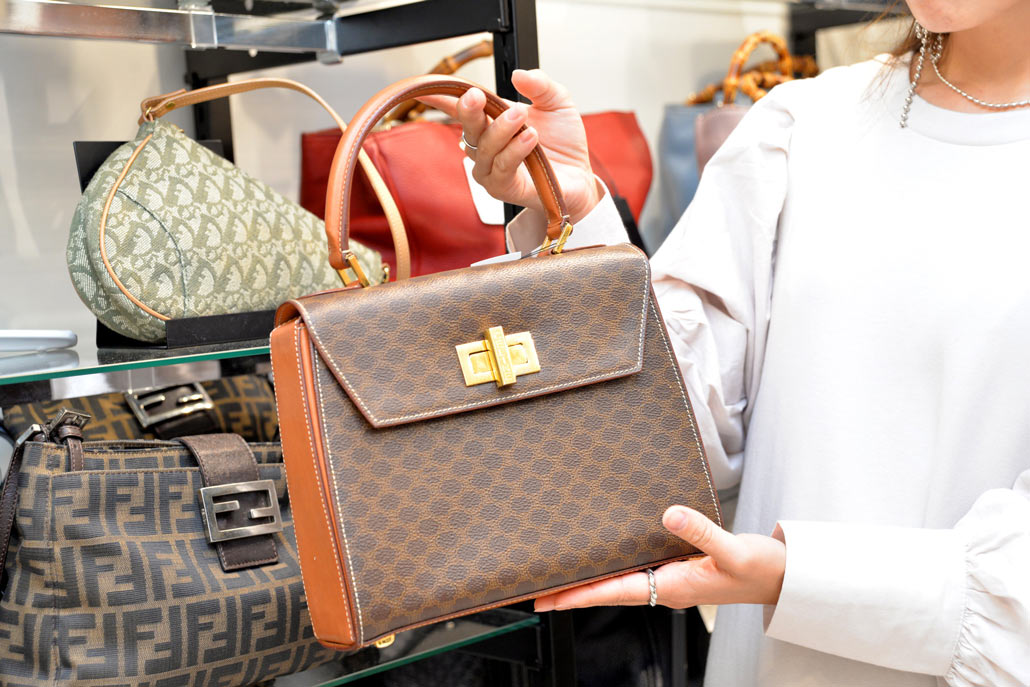 セカンドストリート新宿2号店でCELINE（セリーヌ）のヴィンテージバッグを手に取るfuyumiさん
