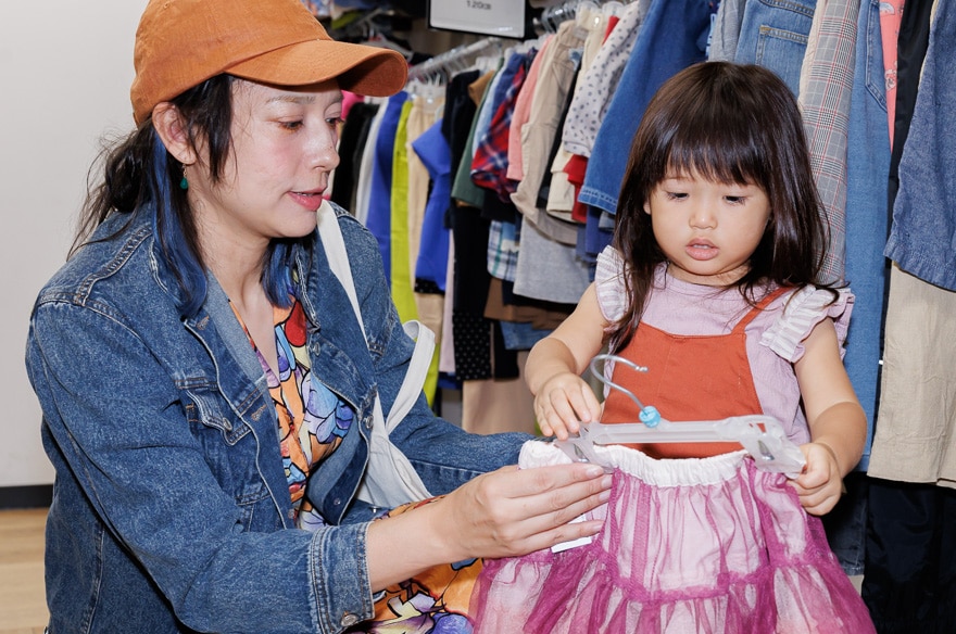 ピンクのスカートを手に取る芳美さん