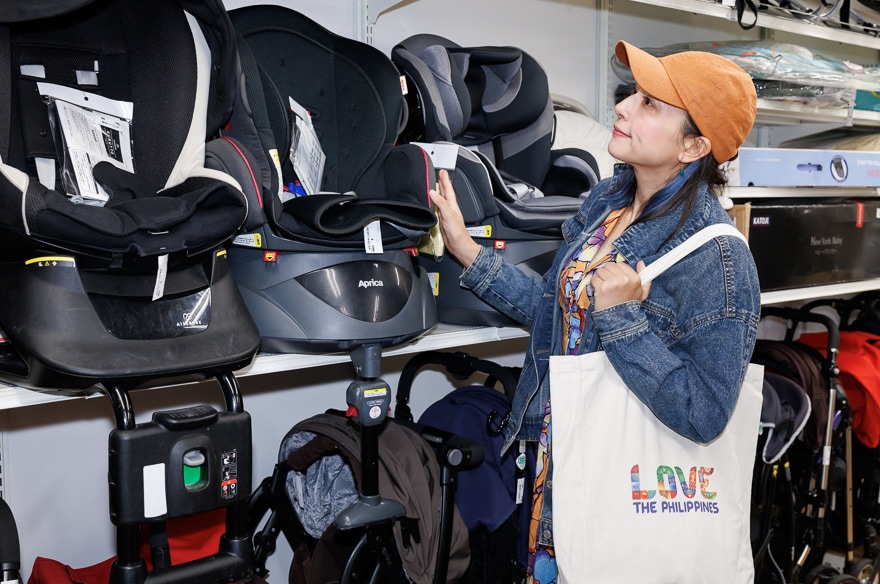 チャイルドシートを前に子育てについて話す芳美さん