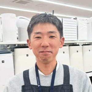 家具家電の売場前でほほ笑む細井店長
